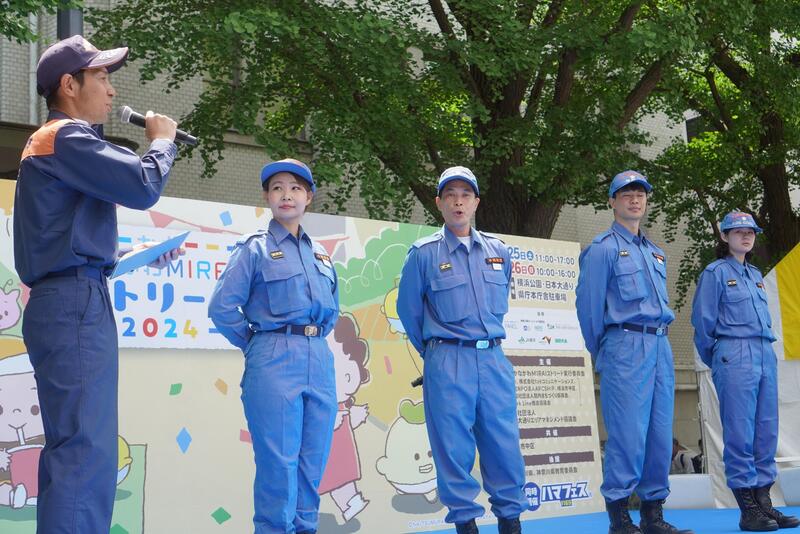 ステージで発表する消防団員と山下消防団係長