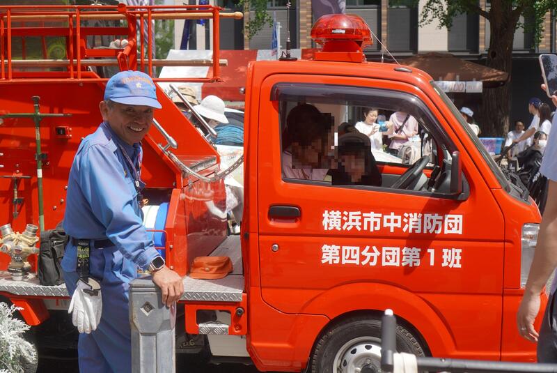 消防団車両で写真を撮る子供たち