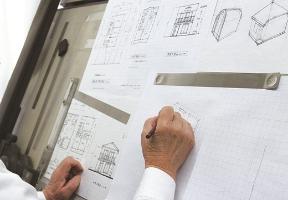 建築士が設計図を描く様子