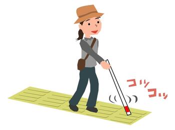 点字ブロックを歩く白状を持った女性