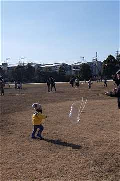 シャボン玉に駆け寄る子どもの写真