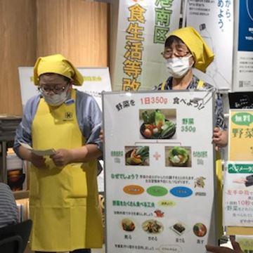 野菜を1日350グラム食べようのパネルを持っている写真