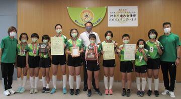 区役所で賞状とトロフィーを持って集合写真