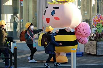 区役所前で小学生が８３太郎に駆け寄っている写真