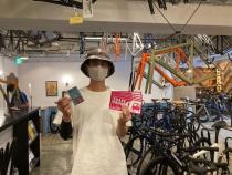 自転車店内で啓発グッズを持った男性の写真