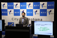 定例記者会見でワクチンplus キャンペーンについて説明する山中市長