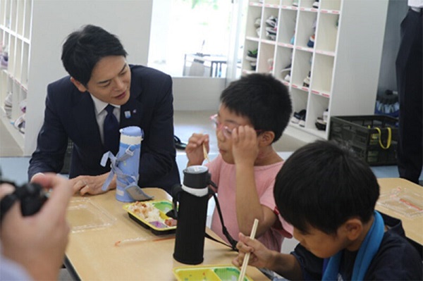 給食を食べる子どもたちを見つめる市長