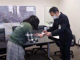 子ども委員が区長と名刺交換している写真
