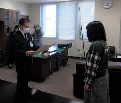区長が委員へ当選証書を渡している写真