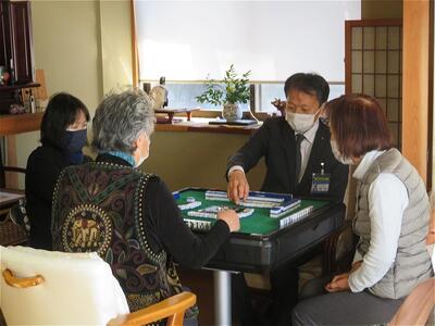 認知症予防麻雀を体験する区長の写真